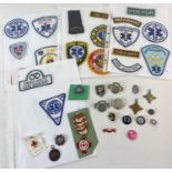 A collection of Emergency services and health care service cloth badges, cap badges pin badges and