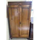 A vintage 1930's oak gentleman's wardrobe with beaded and carved detail to front. Interior has