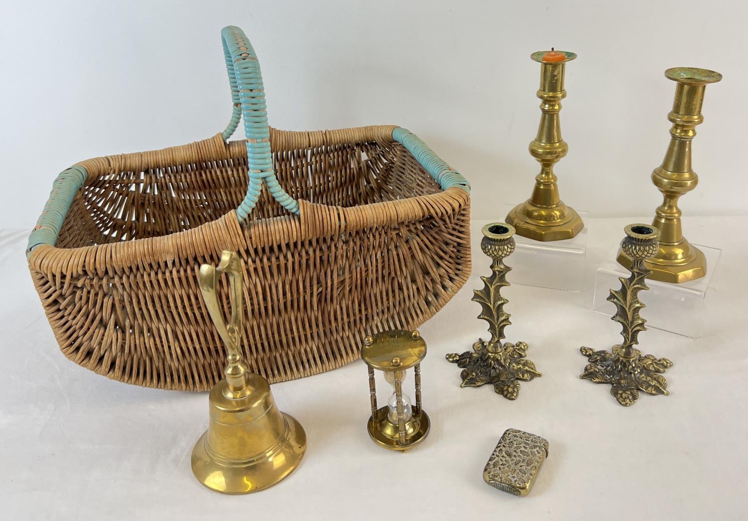 A small collection of assorted vintage brass items, in a 1940's shopping basket. Brass ware to