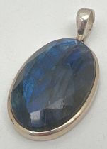 A large oval silver pendant set with a faceted Labradorite stone. Silver marks to bale, Approx. 5.