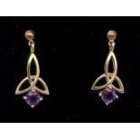 A pair of unmarked 9ct gold and amethyst drop earrings of Celtic design, complete with butterfly