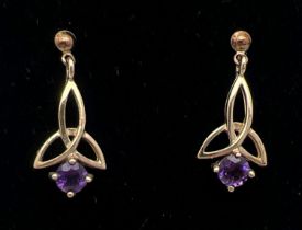 A pair of unmarked 9ct gold and amethyst drop earrings of Celtic design, complete with butterfly