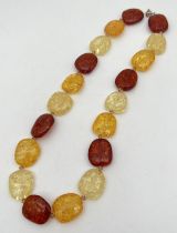 An 18" multi coloured amber beaded necklace with spring ring clasp. Of alternating cognac, honey and