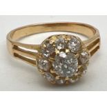 A vintage yellow gold 1ct diamond halo set cluster ring. Central round cut stone surrounded by 9