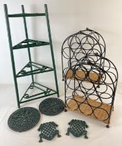 A painted green cast iron 4 tier saucepan stand together with a collection of trivets, one shaped as