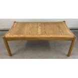 A mid century light wood coffee table with curved edges and square shaped legs. Approx. 41cm tall