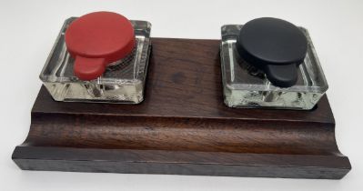 An Art Deco dark oak standish desk stand with double glass inkwells. Square shaped clear glass