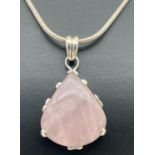 A white metal teardrop shaped pendant set with rose quartz, on an 18" silver snake chain with