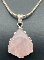 A white metal teardrop shaped pendant set with rose quartz, on an 18" silver snake chain with