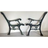 A pair of cast iron bench ends, with remnants of green and black paint. Approx. 78cm tall x 65cm