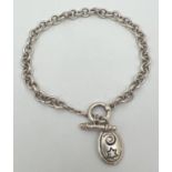 A silver belcher style chain bracelet with T bar clasp and oval charm decorated with star & swirl
