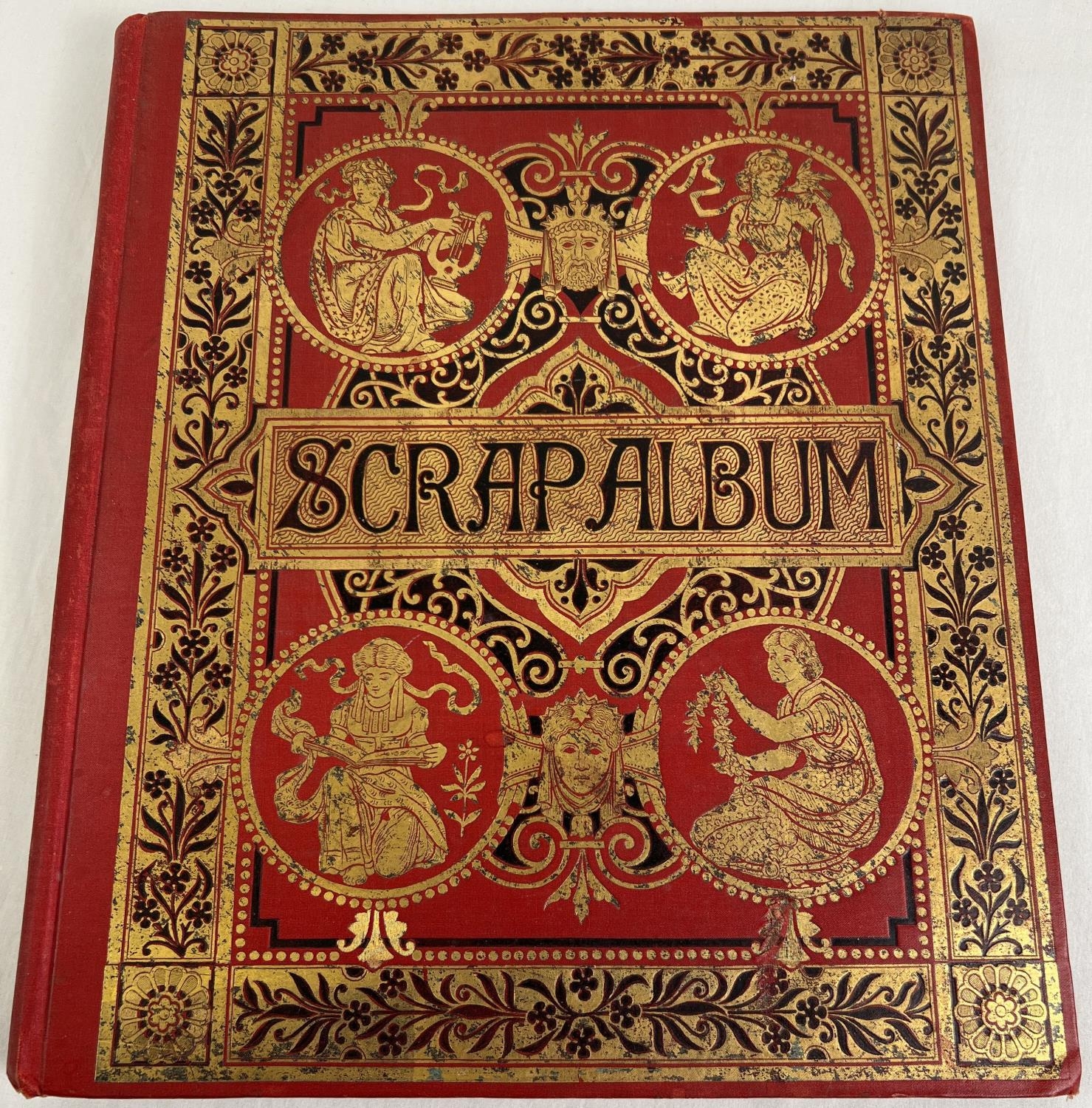 A Victorian red scrap album with decorative gilt design cover, containing assorted scraps &
