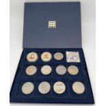 12 collectors coins and commemorative crowns in a Westminster coin collecting box with lift out