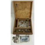 A vintage wooden box of assorted foreign coins and a Bulgarian banknote. To include currency from