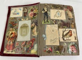 A large Edwardian red velvet scraps album containing assorted scraps and greetings cards.