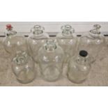 7 assorted clear glass demi-johns in varying sizes.