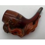 An antique Meerscham style pipe with carved figurehead of a woman holding a cornucopia of flowers.