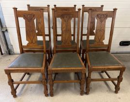 A set of 6 Art Nouveau dark oak dining chairs with turned legs and stylised carved backs. Turned