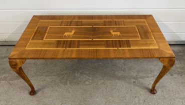 A vintage light wood coffee table, marquetry design to top with stag detail. Raised on cabriole