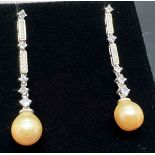 A pair of silver and dark cream pearl drop style earrings each set with 5 small round cut