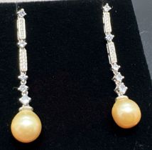 A pair of silver and dark cream pearl drop style earrings each set with 5 small round cut