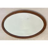 A vintage oval wooden framed bevel edged mirror with inlay detail to frame. Approx. 73 x 42.5cm.