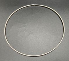 A thin silver torque style necklace with small hook and eye fastening. Worn silver marks to