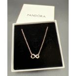 A boxed Pandora silver sparkling infinity collier necklace with adjustable chain.