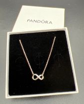 A boxed Pandora silver sparkling infinity collier necklace with adjustable chain.