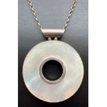 A large silver circular shaped pendant set with Mother Of Pearl, on a 24" belcher chain with