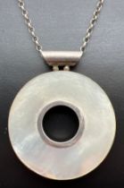 A large silver circular shaped pendant set with Mother Of Pearl, on a 24" belcher chain with