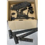 A box of vintage painted black metal hardware for doors. To include pairs of hinges, a letter box,