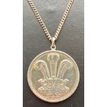 A vintage silver circular pendant with Welsh Dragon to one side and Prince Of Wales feathers to