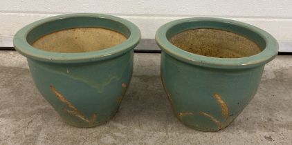 A pair of pale green glazed garden pots with foliate design. Approx. 22cm tall x 26cm diameter.