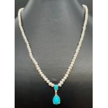 An 18 inch seed pearl necklace with turquoise drop and silver clasp. Silver marks to clasp and