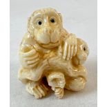 A carved netsuke models as monkeys, with signature mark to underside, possibly bone. Approx. 4cm