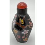 A small black ceramic hexagonal shaped snuff bottle with hand painted floral decoration. Approx. 6.