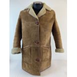 A ladies vintage sheepskin coat by Nurserys. Traditional button fastening to front with fleece turne