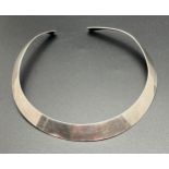 A modern silver torque style necklace. Silver marks to under side. Band width approx. 1.25cm at