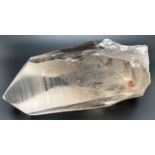 A large smoked quartz crystal point with natural orange and red inclusions. Approx. 24cm long x 10cm