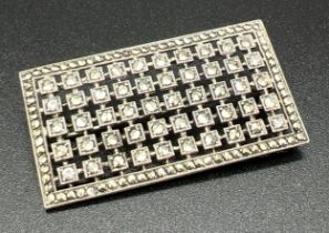 An Art Deco square shaped silver brooch set with marcasite and clear stones. Marked 935 to back.