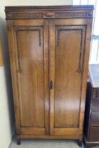 A vintage 1930's oak gentleman's wardrobe with beaded and carved detail to front. Interior has
