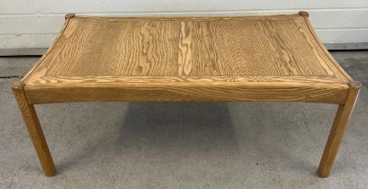 A mid century light wood coffee table with curved edges and square shaped legs. Approx. 41cm tall