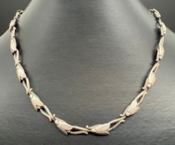 A 17 inch floral link silver necklace with lobster style clasp. Silver marks to clasp and back of