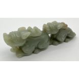 A small piece of Chinese carved green jade modelled as Foo dogs. Approx. 3cm tall x 10cm long.
