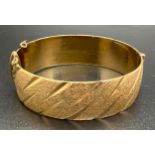A vintage 9ct rolled gold bangle with brushed effect and diamond cut pattern. Marks to inside of