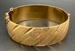 A vintage 9ct rolled gold bangle with brushed effect and diamond cut pattern. Marks to inside of