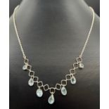 A modern design 18 inch fixed pendant silver necklace with round, oval and teardrop cut blue topaz