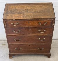 An antique oak 4 drawer bureau with internal stationery compartments and brass drop down handles.