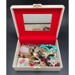 A large vintage cream coloured jewellery box and contents to include gold tone and beaded